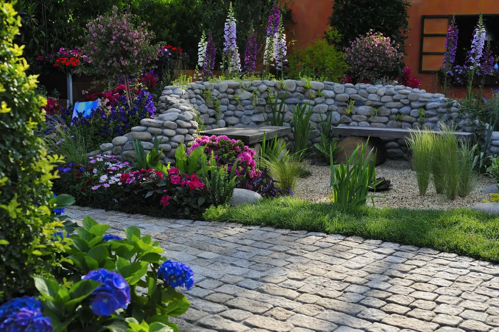 Designed garden with flowering perennials and stone bench